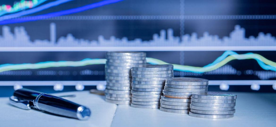 Stack of money coin with trading graph.